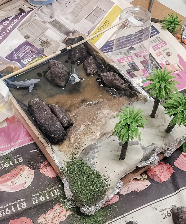 A model of a river with rocks and palm trees

AI-generated content may be incorrect.