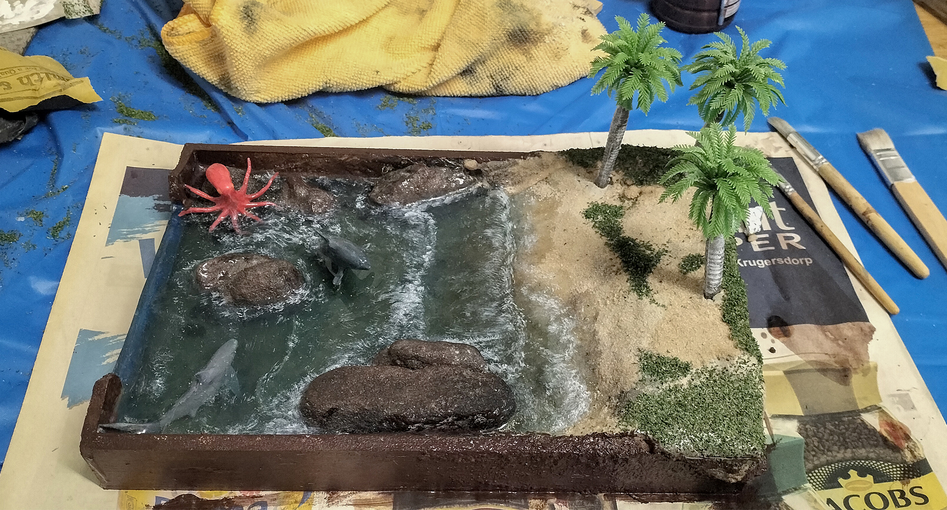 A model of a river with palm trees and rocks

AI-generated content may be incorrect.